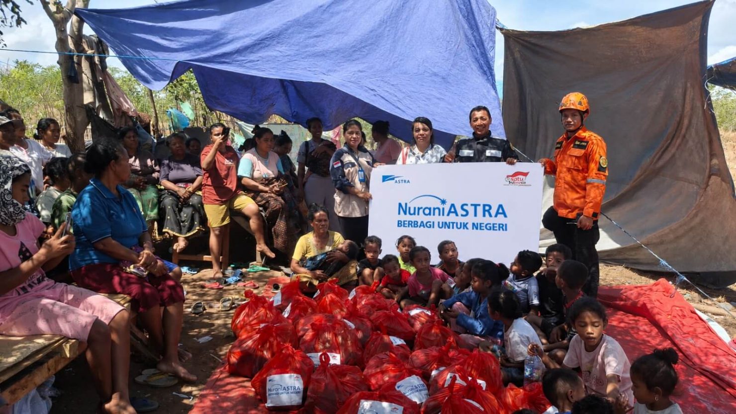 Masyarakat terdampak gempa bumi bersama relawan Nurani Astra mengikuti kegiatan penyaluran bantuan kebutuhan dasar berupa paket sembako di salah satu wilayah terdampak gempa bumi di Nusa Tenggara Timur, sebagai bagian dari dukungan Astra dalam membantu memenuhi kebutuhan masyarakat selama masa tanggap darurat.