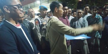 Kepala Desa Tenggor Kowiyanto menyampaikan hasil laporan di depan warganya di halaman Polres Gresik.