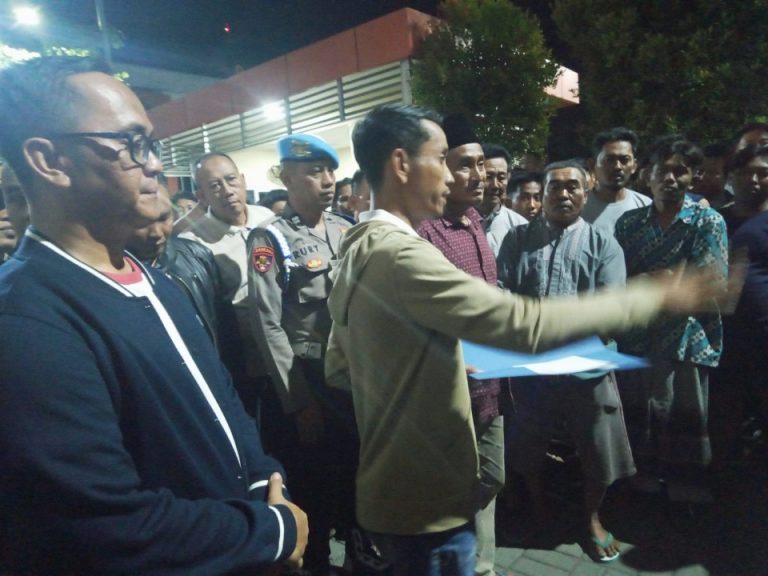 Kepala Desa Tenggor Kowiyanto menyampaikan hasil laporan di depan warganya di halaman Polres Gresik.