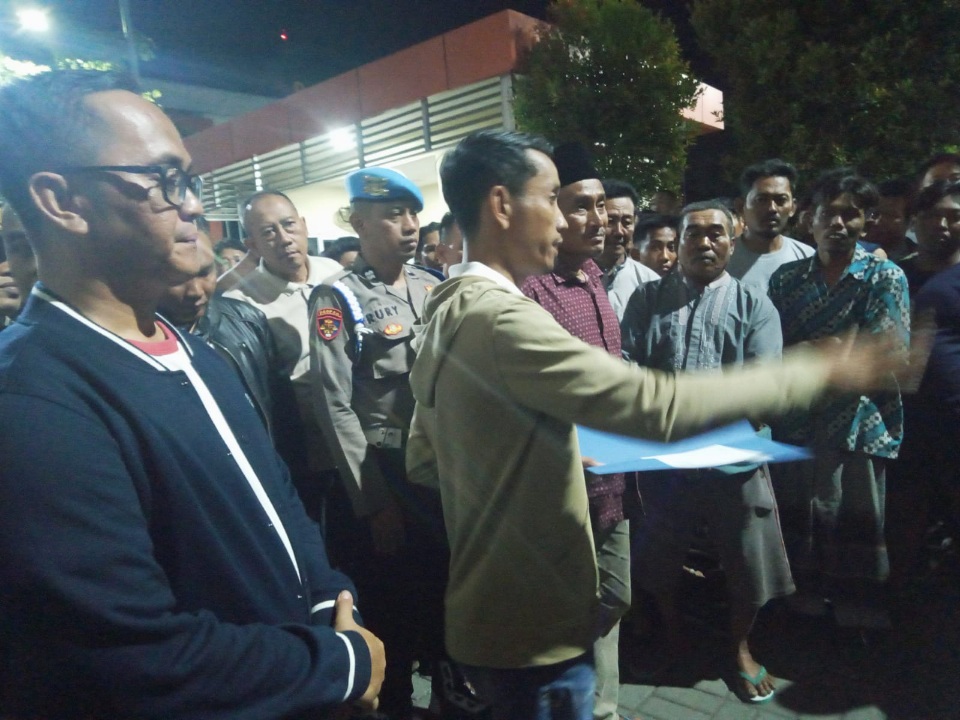 Kepala Desa Tenggor Kowiyanto menyampaikan hasil laporan di depan warganya di halaman Polres Gresik.