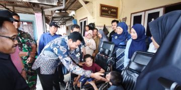 Bupati Sidoarjo, Subandi, saat menyerahkan bantuan kursi roda pada Arafah dan Arafih, warga Desa Banjarbendo.