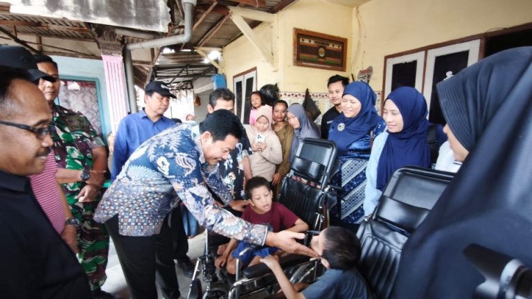 Bupati Sidoarjo, Subandi, saat menyerahkan bantuan kursi roda pada Arafah dan Arafih, warga Desa Banjarbendo.