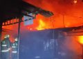 Petugas berusaha memadamkan api saat kebakaran tiga warung di Desa Wage Sidoarjo.