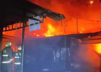 Petugas berusaha memadamkan api saat kebakaran tiga warung di Desa Wage Sidoarjo.
