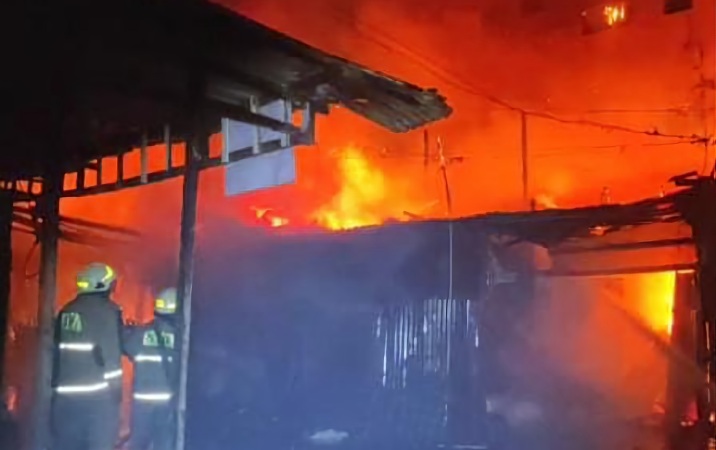 Petugas berusaha memadamkan api saat kebakaran tiga warung di Desa Wage Sidoarjo.