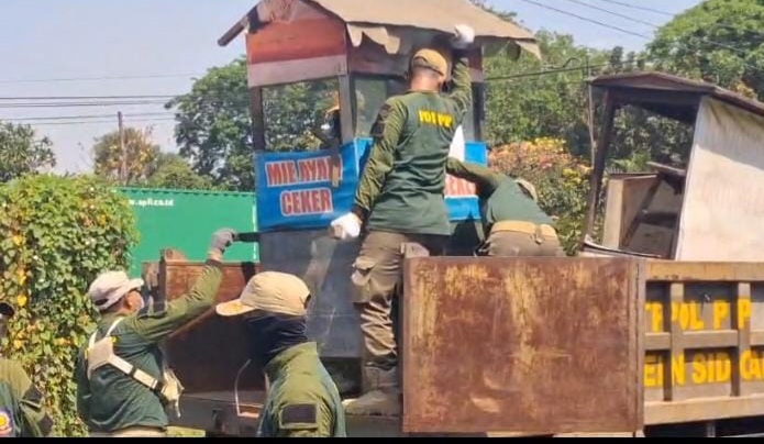 Petugas Satpol PP Sidoarjo, saat melakukan penertiban bangli di jalur frontage road Waru Sidoarjo.