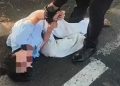 Petugas patroli Polresta Sidoarjo, saat berupaya membujuk dan meminta perempuan yang tengah menangis dan berguling di aspal jalan untuk menepi ke tempat yang lebih aman.
