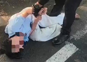 Petugas patroli Polresta Sidoarjo, saat berupaya membujuk dan meminta perempuan yang tengah menangis dan berguling di aspal jalan untuk menepi ke tempat yang lebih aman.